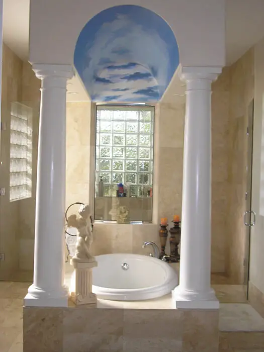 bathtub with elegant pillars ceiling mural of sky
