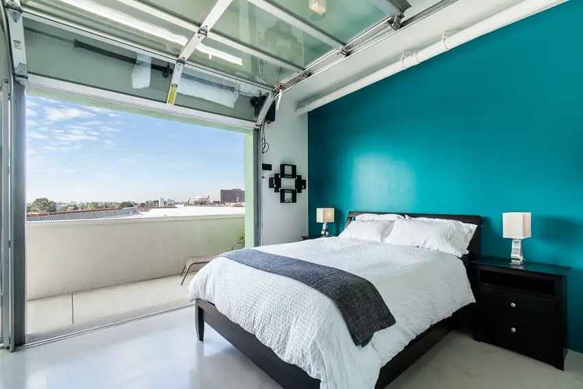 Bedroom with Roll Up Door Teal Accent Wall Balcony and City Views