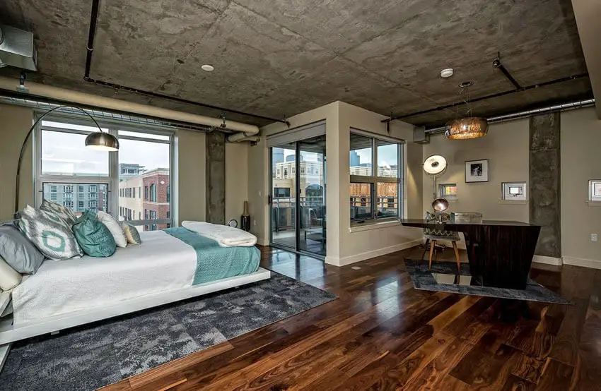 Contemporary Loft Bedroom with Balcony Wood Floors Concrete Ceiling and Exposed Duct Work