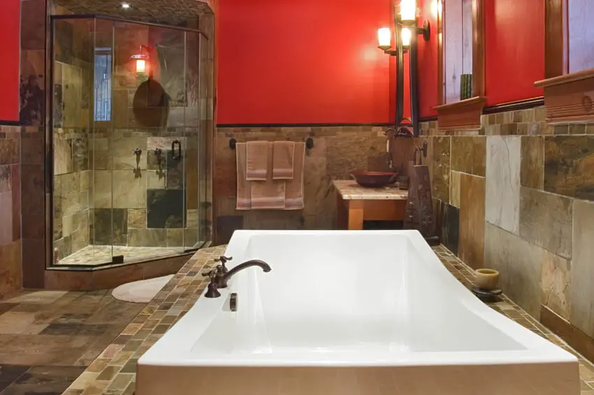 luxurious tub in bathroom with red walls