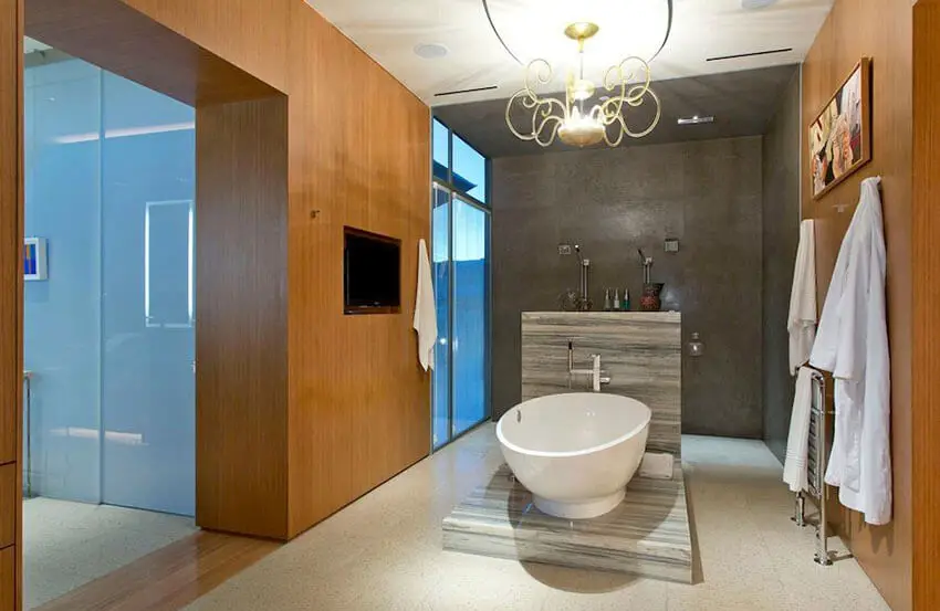 Modern bathroom with elevated freestanding tub and gold chandelier