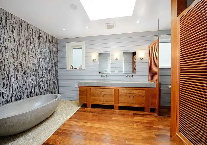 Modern master bathroom with custom travertine bathtub and naatural river rock floor