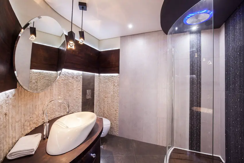 modern shower in bathroom with round mirror