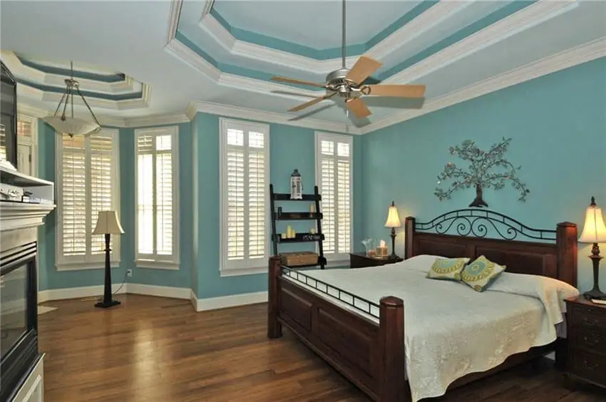 Traditional Bedroom with Teal Painted Walls Wood Flooring and White Molding